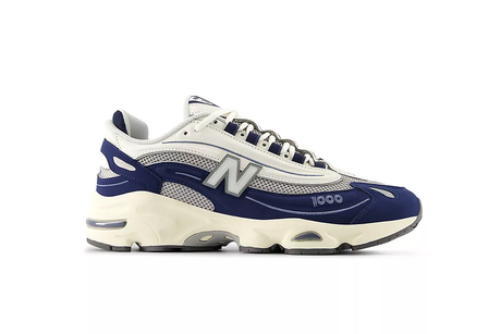 A pair of New Balance M1000MEN sneakers featuring a mesh and suede upper with a blue, white, and beige color scheme, and an external lacing structure.