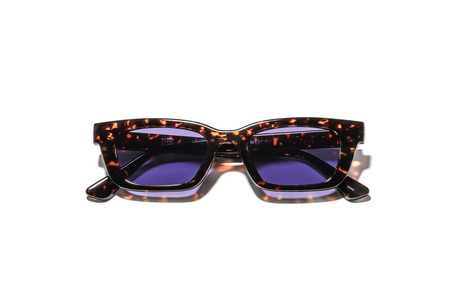 Sunglasses with tortoiseshell frame and purple lenses on a white background
