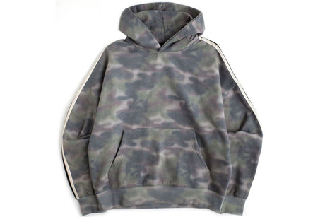A camouflage hoodie with a gray, green, and black pattern, featuring white stripes down the sleeves, laid flat against a white background.