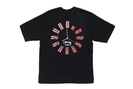 A black Stussy t-shirt featuring a creative 'clock' design on the front where the clock hands are replaced by red and white domino tiles, with the Stussy logo printed in the center.