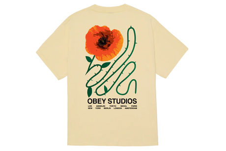 Beige t-shirt with a graphic of an orange flower and green leaves on the back, featuring the 'Obey Studios' logo.