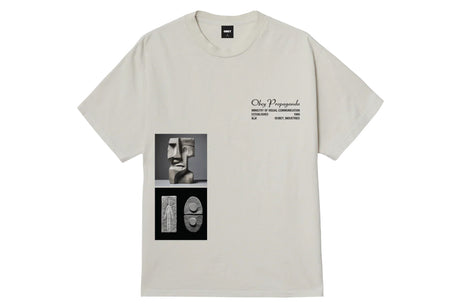 A light beige short-sleeve t-shirt with a graphic print on the front. The graphic features a black-and-white portrait of a sculptor's face above two abstract black-and-white geometric designs.