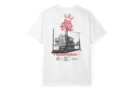 A white short-sleeve t-shirt with a large graphic print on the back. The graphic features a red crown and 'Pils' logo above a black-and-white sketch of a Philadelphia brewery building, with 'Philadelphia' printed in red below.
