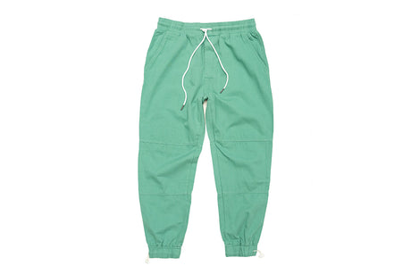 Green jogger pants with elastic waistband and adjustable ankles, featuring a drawstring and pockets on the sides.