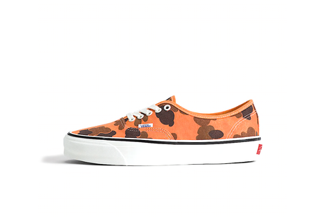 Orange sneaker with black pattern on a white background