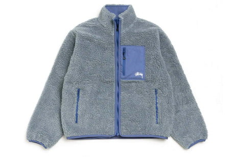 SHERPA REVERSIBLE JACKET WITH GREY SHERPA AND TAPING DETAILS ON A WHITE BACKGROUND.