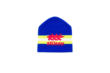 A royal blue knit beanie hat featuring a horizontal yellow stripe with a red graphic logo and the text 'stussy' in red, set against a plain white background.