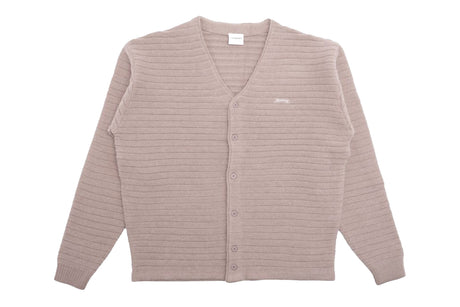 Beige cardigan with buttons laying on a white background.