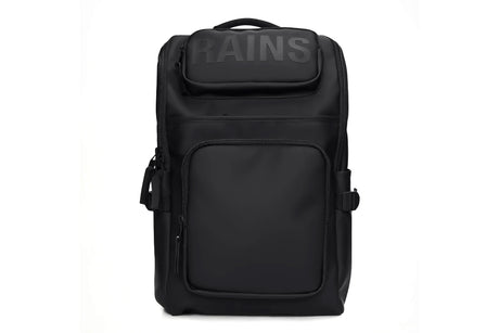 A black Rains backpack with a top flap featuring the brand name 'RAINS' in dark gray lettering, shown against a plain white background.