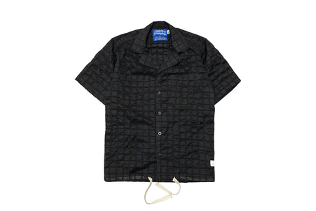 Black quilted jacket with a brand label on a white background
