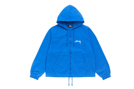 A bright blue zip-up hooded jacket with a white embroidered Stussy logo on the left chest, displayed flat against a solid white background.